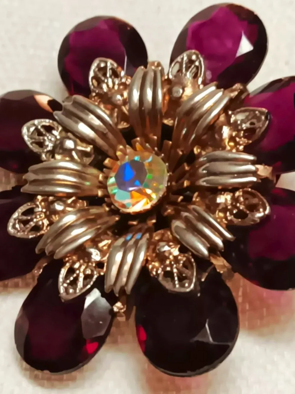 Vintage ruby lucite brooch with aurora borealis central rhinestone.
